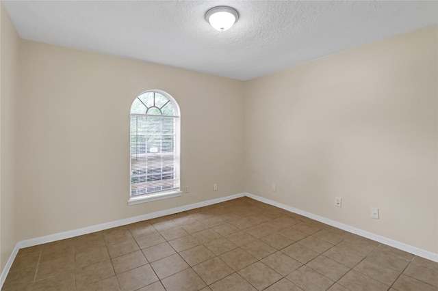 10211 Golden Meadow Dr, Houston, TX 77064 - empty room featuring light tile patterned floors, a textured ceiling, and baseboards
