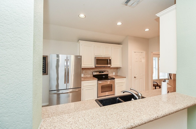 21126 N Yellow Bud Ct, Cypress, TX 77433 - kitchen featuring appliances with stainless steel finishes, a sink, backsplash, recessed lighting, and white cabinetry