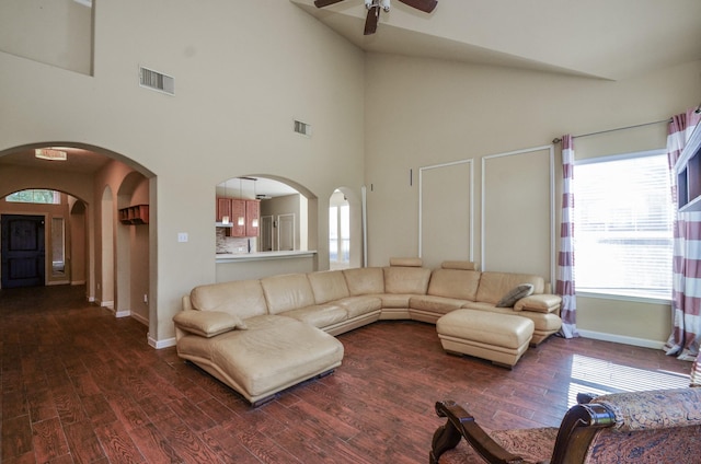 17719 Creek Bluff Ln, Cypress, TX 77433 - living room with ceiling fan, baseboards, dark wood finished floors, a towering ceiling, and arched walkways
