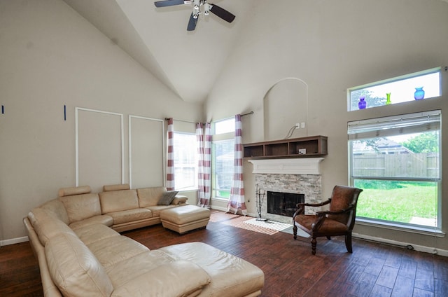 17719 Creek Bluff Ln, Cypress, TX 77433 - living room with dark wood-style flooring, a stone fireplace, high vaulted ceiling, a ceiling fan, and baseboards