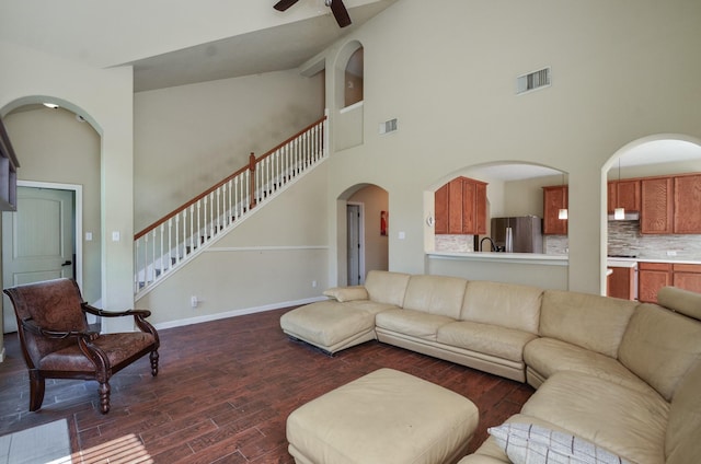 17719 Creek Bluff Ln, Cypress, TX 77433 - living area with high vaulted ceiling, dark wood finished floors, a ceiling fan, arched walkways, and stairway