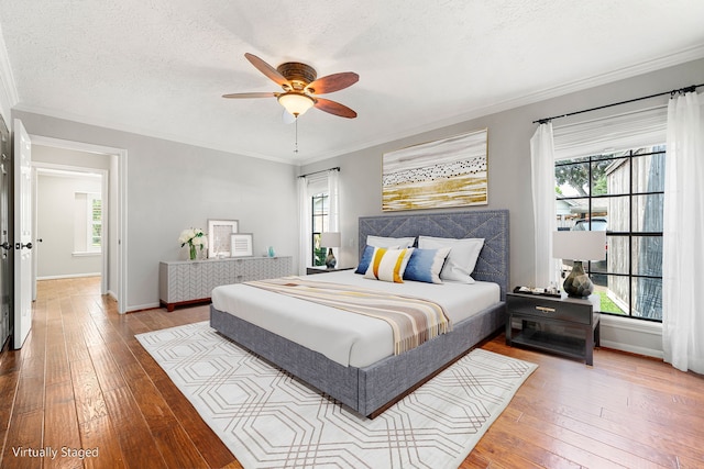 1907 Round Lake Dr, Houston, TX 77077 - bedroom featuring multiple windows, hardwood / wood-style flooring, ornamental molding, baseboards, and a textured ceiling