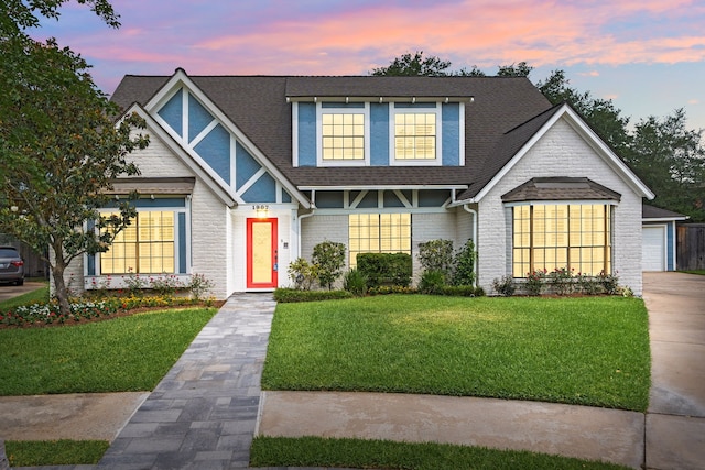 1907 Round Lake Dr, Houston, TX 77077 - view of front facade with a shingled roof, a yard, brick siding, and a garage