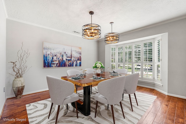 1907 Round Lake Dr, Houston, TX 77077 - dining space featuring a chandelier, a textured ceiling, light wood finished floors, ornamental molding, and baseboards