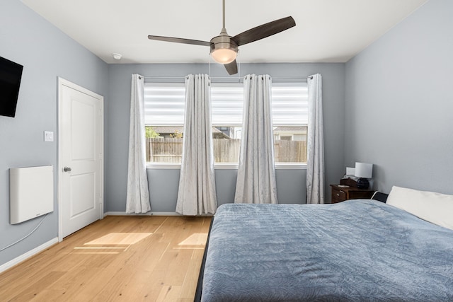19253 Hazel Firs Ct, Magnolia, TX 77355 - bedroom featuring wood finished floors, multiple windows, baseboards, and ceiling fan