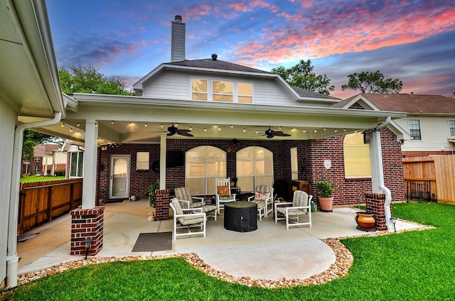 17619 Rustling Aspen Ln, Houston, TX 77095 - back of property at dusk with a ceiling fan, brick siding, a patio, and a chimney