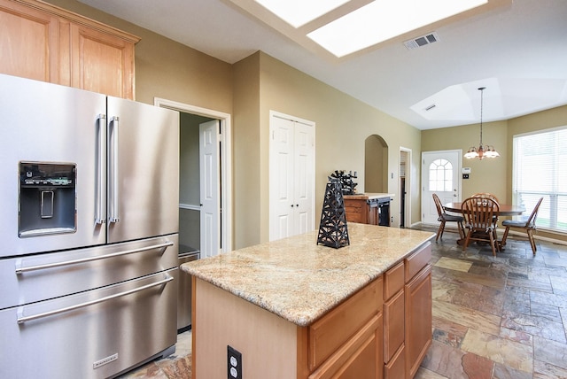 17619 Rustling Aspen Ln, Houston, TX 77095 - kitchen featuring stainless steel fridge, stone tile flooring, arched walkways, a center island, and light stone countertops