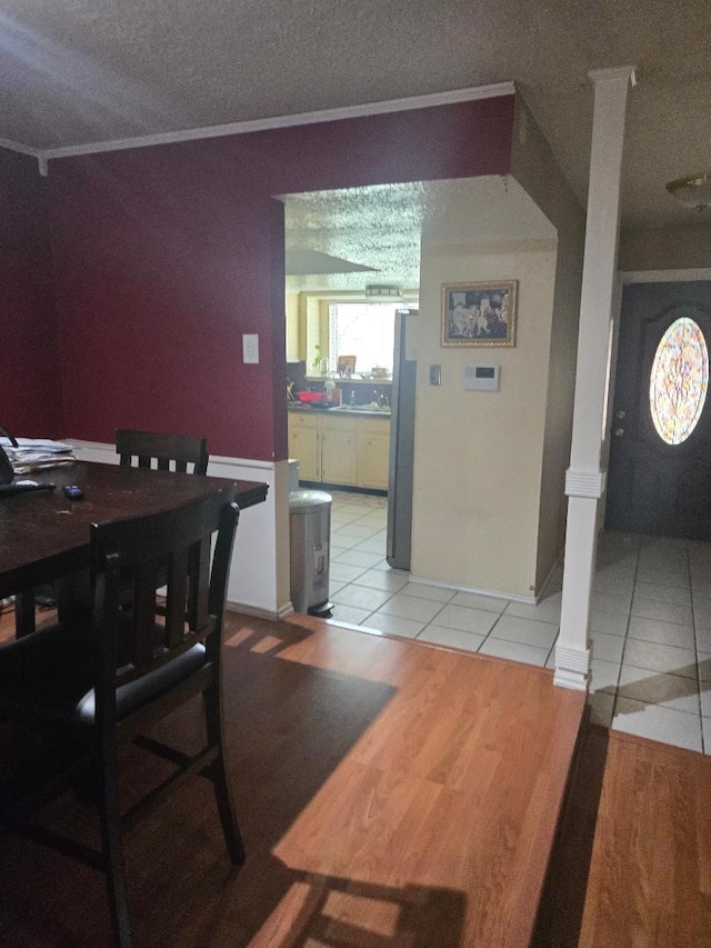 6815 Maczali Dr, Houston, TX 77489 - dining area featuring decorative columns, light tile patterned flooring, ornamental molding, and a textured ceiling