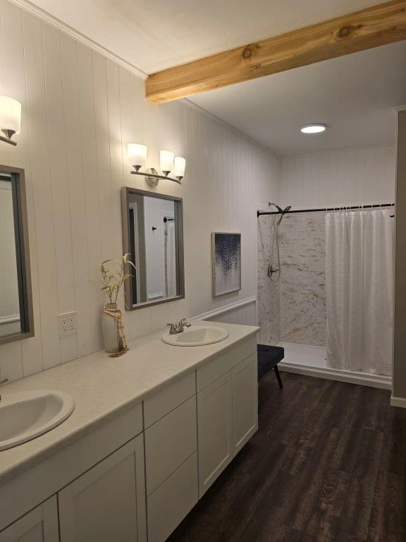 334 Wilcrest Dr Unit 334, Houston, TX 77042 - bathroom with beamed ceiling, tiled shower, double vanity, wood finished floors, and crown molding