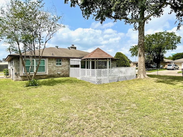 13011 Harwin Dr, Houston, TX 77072 - rear view of property featuring a yard, a chimney, and brick siding