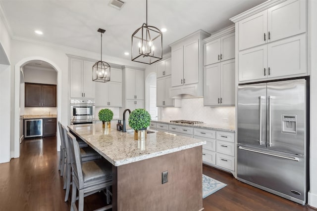 1746 Du Barry Ln, Houston, TX 77018 - kitchen featuring stainless steel appliances, arched walkways, a chandelier, recessed lighting, and tasteful backsplash