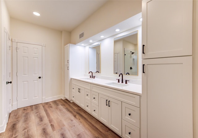 16727 Camber Ct, Crosby, TX 77532 - full bathroom with double vanity, a shower with shower door, wood finished floors, recessed lighting, and baseboards