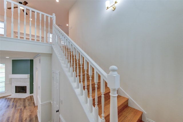 16727 Camber Ct, Crosby, TX 77532 - stairway with wood finished floors, a fireplace with flush hearth, recessed lighting, and baseboards