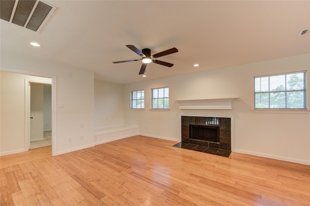 16727 Camber Ct, Crosby, TX 77532 - unfurnished living room with light wood finished floors, recessed lighting, a tiled fireplace, ceiling fan, and baseboards
