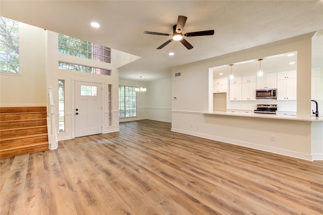 16727 Camber Ct, Crosby, TX 77532 - unfurnished living room featuring a ceiling fan, stairway, light wood-type flooring, ornamental molding, and recessed lighting