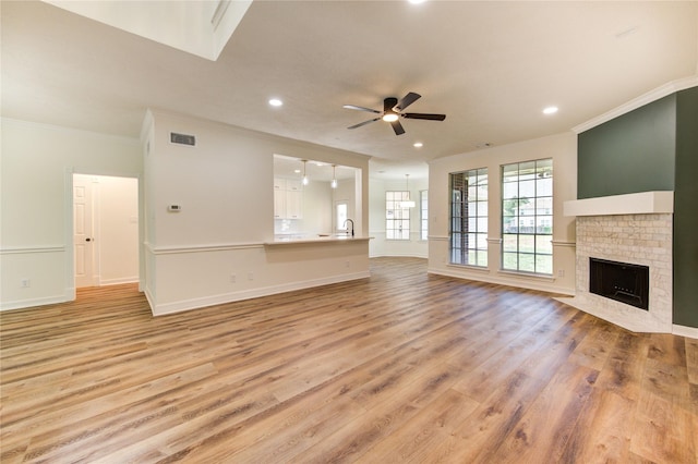 16727 Camber Ct, Crosby, TX 77532 - unfurnished living room featuring ornamental molding, ceiling fan, light wood-type flooring, recessed lighting, and a brick fireplace