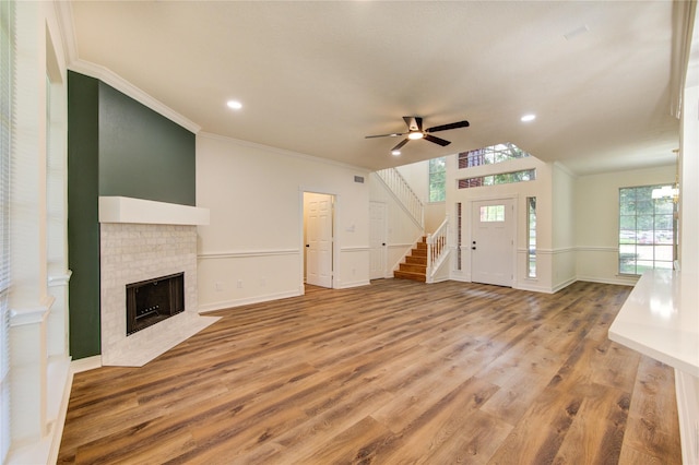 16727 Camber Ct, Crosby, TX 77532 - unfurnished living room featuring ornamental molding, stairs, wood finished floors, a ceiling fan, and a fireplace with flush hearth