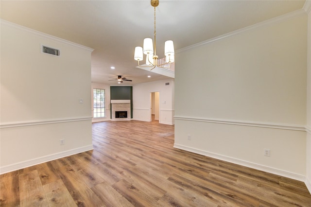 16727 Camber Ct, Crosby, TX 77532 - spare room with ornamental molding, wood finished floors, a chandelier, a fireplace, and ceiling fan