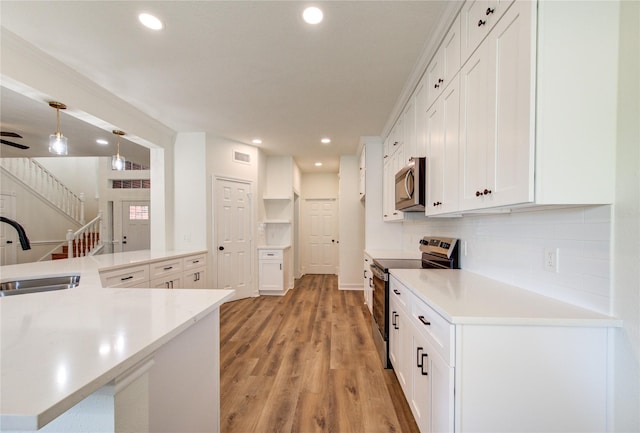 16727 Camber Ct, Crosby, TX 77532 - kitchen with stainless steel appliances, a sink, recessed lighting, white cabinets, and light countertops