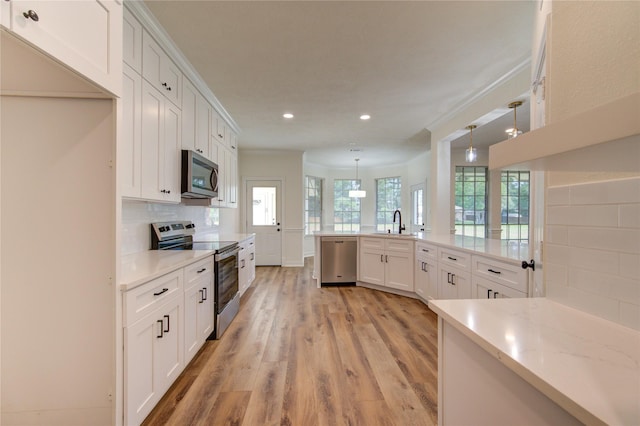 16727 Camber Ct, Crosby, TX 77532 - kitchen with stainless steel appliances, a sink, light wood finished floors, recessed lighting, and white cabinets