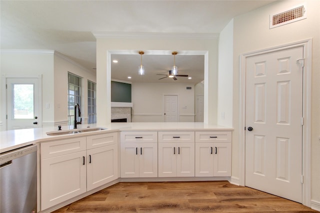16727 Camber Ct, Crosby, TX 77532 - kitchen with stainless steel dishwasher, a sink, a ceiling fan, white cabinetry, and light wood-type flooring