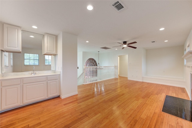 16727 Camber Ct, Crosby, TX 77532 - kitchen with light wood-style floors, white cabinets, ceiling fan, light countertops, and recessed lighting