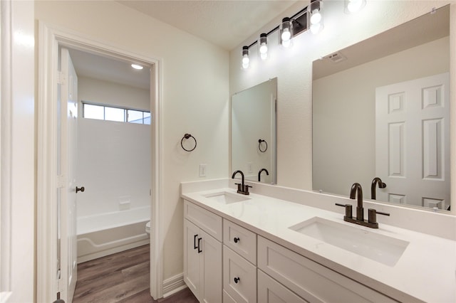 16727 Camber Ct, Crosby, TX 77532 - full bath with toilet, double vanity, wood finished floors, and washtub / shower combination