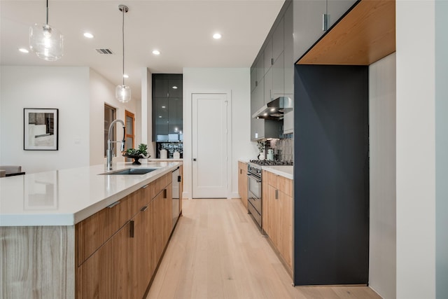 1851 Sul Ross St, Houston, TX 77098 - kitchen with stainless steel gas range, a sink, modern cabinets, light wood-style flooring, and recessed lighting
