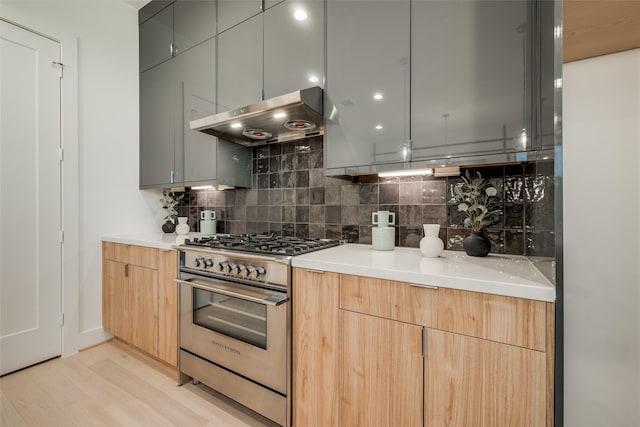1851 Sul Ross St, Houston, TX 77098 - kitchen featuring stainless steel range, range hood, backsplash, light wood-style floors, and light countertops