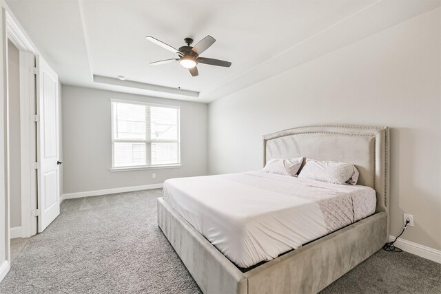 19303 Belmont Stakes Way, Tomball, TX 77377 - bedroom with light carpet, baseboards, a raised ceiling, and ceiling fan
