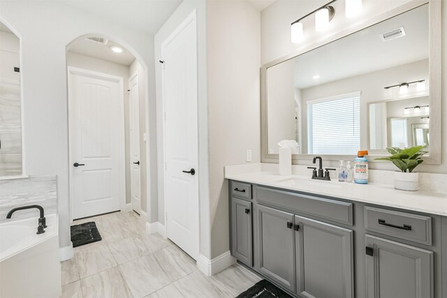 19303 Belmont Stakes Way, Tomball, TX 77377 - bathroom with vanity, a garden tub, marble look tiles, and baseboards