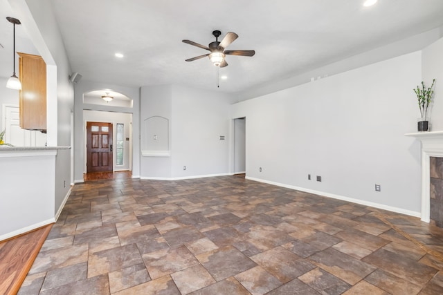 9515 Willow Crossing Dr, Houston, TX 77064 - unfurnished living room featuring ceiling fan, dark stone finish flooring, arched walkways, recessed lighting, and baseboards