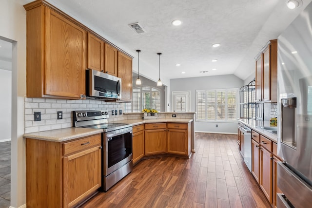 9515 Willow Crossing Dr, Houston, TX 77064 - kitchen with stainless steel appliances, a peninsula, baseboards, light countertops, and tasteful backsplash