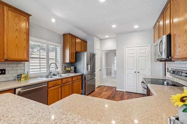 9515 Willow Crossing Dr, Houston, TX 77064 - kitchen with stainless steel appliances, a sink, dark wood-type flooring, decorative backsplash, and brown cabinetry