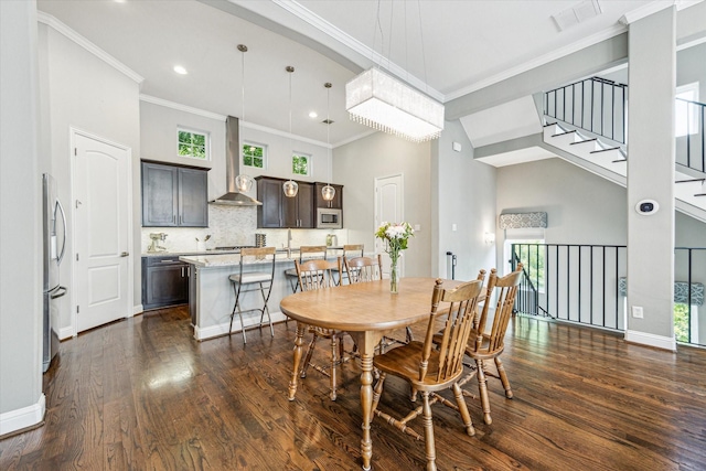 6123 Stillman St, Houston, TX 77007 - dining area with dark wood finished floors, crown molding, baseboards, stairway, and recessed lighting