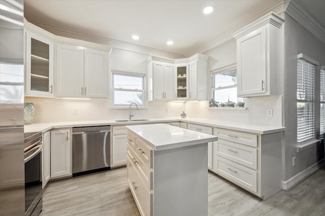 22409 Vista Del Mar, Galveston, TX 77554 - kitchen featuring appliances with stainless steel finishes, a sink, plenty of natural light, light wood-type flooring, and crown molding