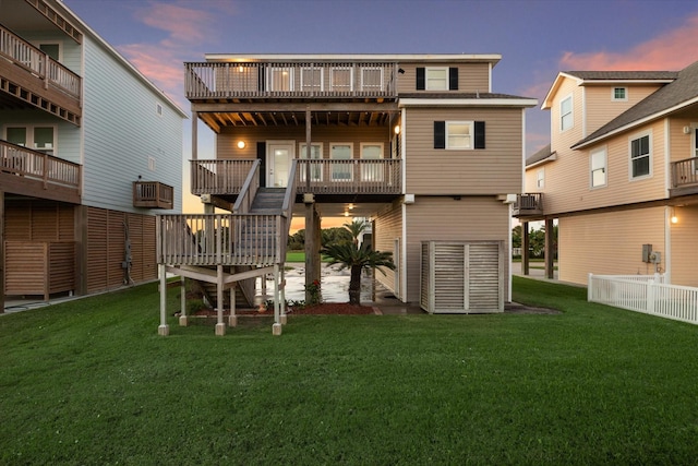 22409 Vista Del Mar, Galveston, TX 77554 - back of property at dusk featuring a lawn and a wooden deck