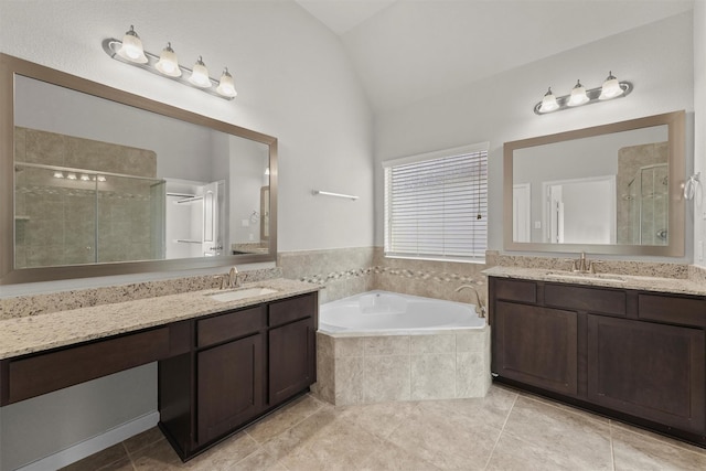 9611 Knights Station Dr, Houston, TX 77045 - full bathroom featuring vaulted ceiling, a stall shower, two vanities, tile patterned flooring, and a garden tub