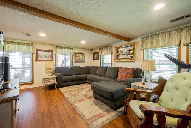 12857 Fm 1485th Rd, Conroe, TX 77306 - living room featuring a textured ceiling, beam ceiling, healthy amount of natural light, wood finished floors, and recessed lighting