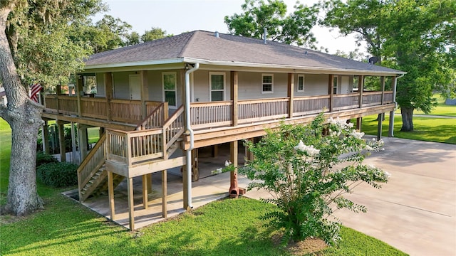 915 Live Oak Dr, Jones Creek, TX 77541 - back of house featuring a shingled roof, a lawn, stairs, and a patio