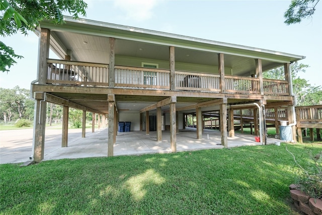 915 Live Oak Dr, Jones Creek, TX 77541 - back of house featuring a carport, a lawn, a patio area, and a wooden deck