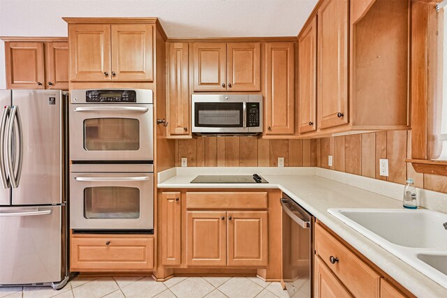 2920 Heron Dr, Galveston, TX 77551 - kitchen with stainless steel appliances, light countertops, and light tile patterned flooring