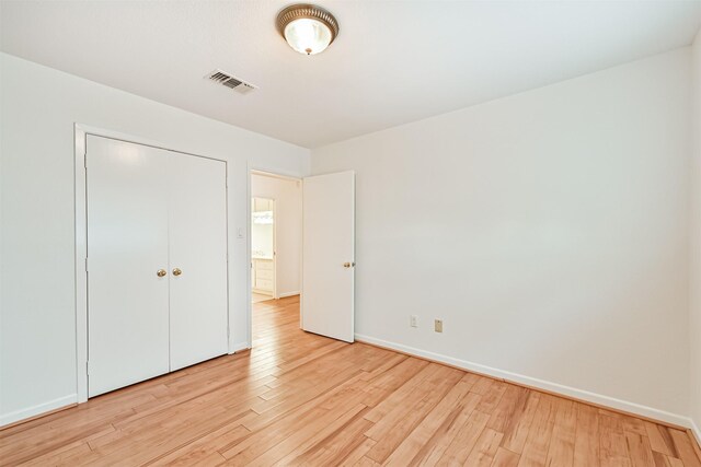 2920 Heron Dr, Galveston, TX 77551 - unfurnished bedroom featuring light wood-style flooring, baseboards, and a closet