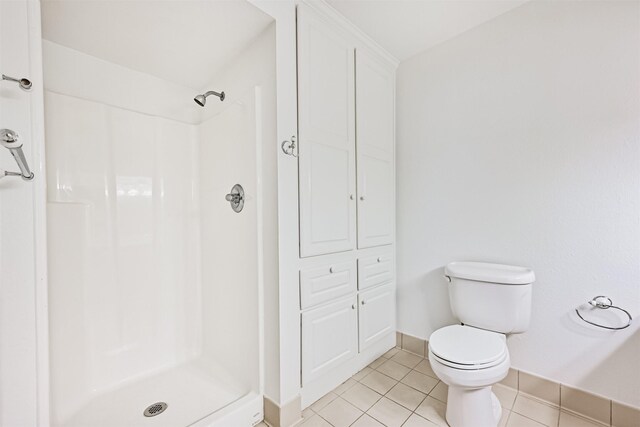 2920 Heron Dr, Galveston, TX 77551 - full bathroom featuring baseboards, a shower, tile patterned flooring, and toilet