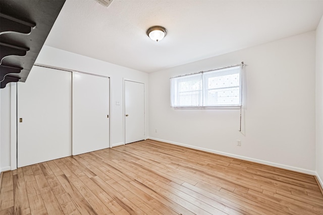 2920 Heron Dr, Galveston, TX 77551 - unfurnished bedroom with light wood-type flooring and baseboards