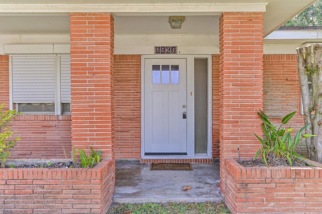 2920 Heron Dr, Galveston, TX 77551 - view of exterior entry featuring brick siding