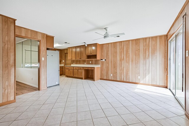 2920 Heron Dr, Galveston, TX 77551 - kitchen featuring freestanding refrigerator, a ceiling fan, baseboards, wood walls, and light countertops