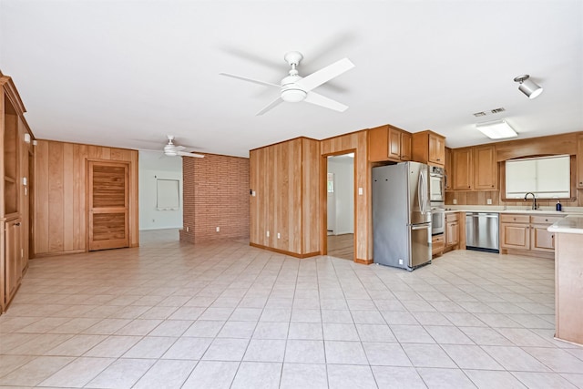 2920 Heron Dr, Galveston, TX 77551 - kitchen featuring stainless steel appliances, ceiling fan, light countertops, wooden walls, and open floor plan