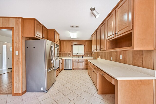 2920 Heron Dr, Galveston, TX 77551 - kitchen with appliances with stainless steel finishes, light countertops, a sink, and light tile patterned flooring