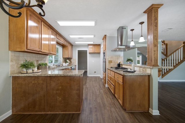 15735 Mesa Gardens Dr, Houston, TX 77095 - kitchen featuring island exhaust hood, a peninsula, a sink, stainless steel appliances, and baseboards